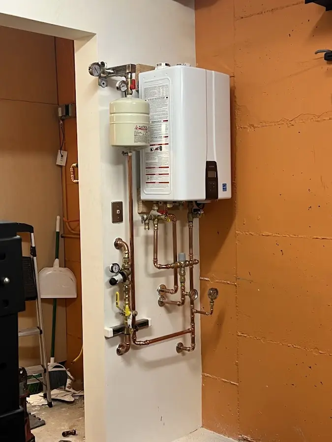 Plumbing technician inspecting water heater connections in Hoopeston